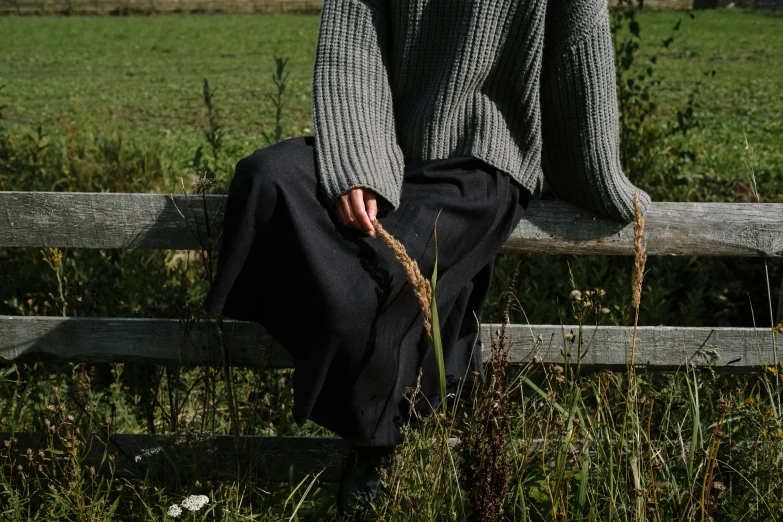 a man is sitting down on a bench and holding a stick