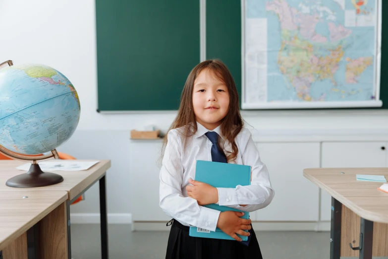 a girl is holding a blue folder in her classroom