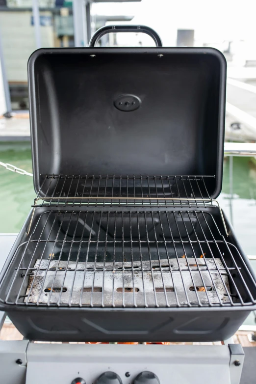 a grill sitting next to a river filled with water