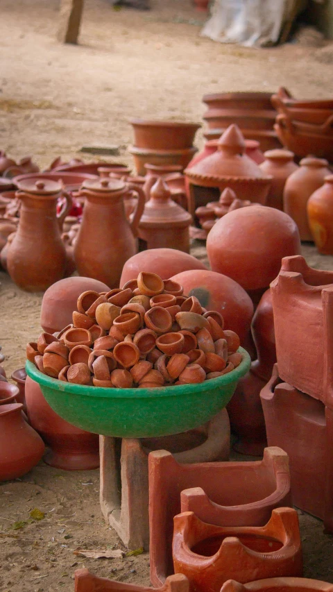 many clay pots, vases and bowls are laying on the ground