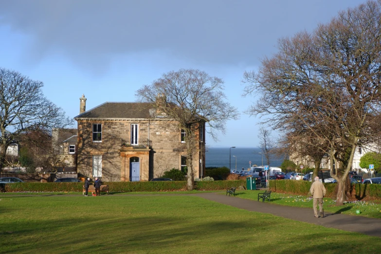 the man is walking towards a house by the water