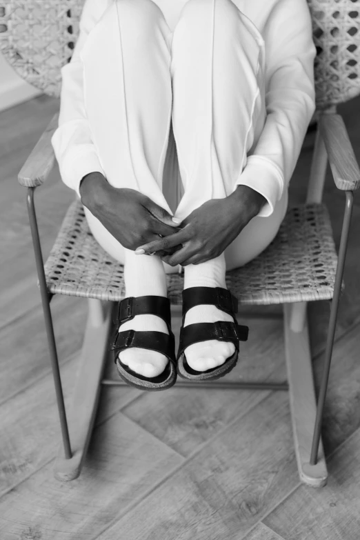 a man with striped shoes sits on a folding chair