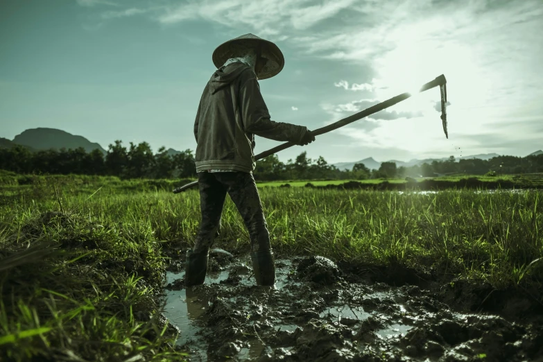 a person is standing in the mud with a stick