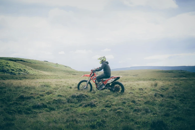 a man is on a red bike in a field