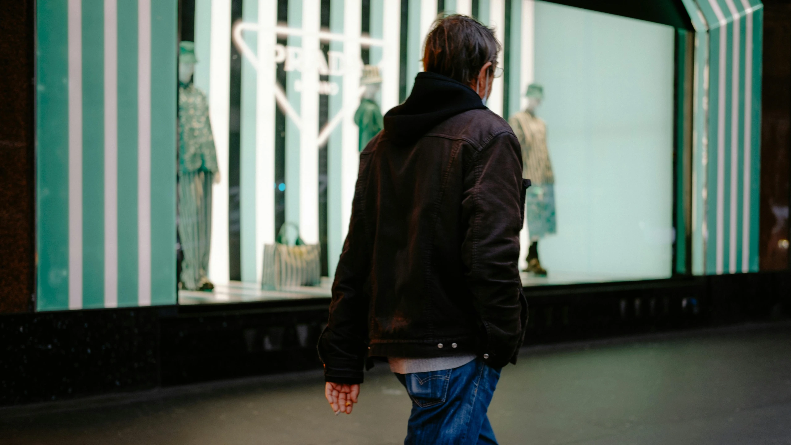 a man walking down a street in front of a store