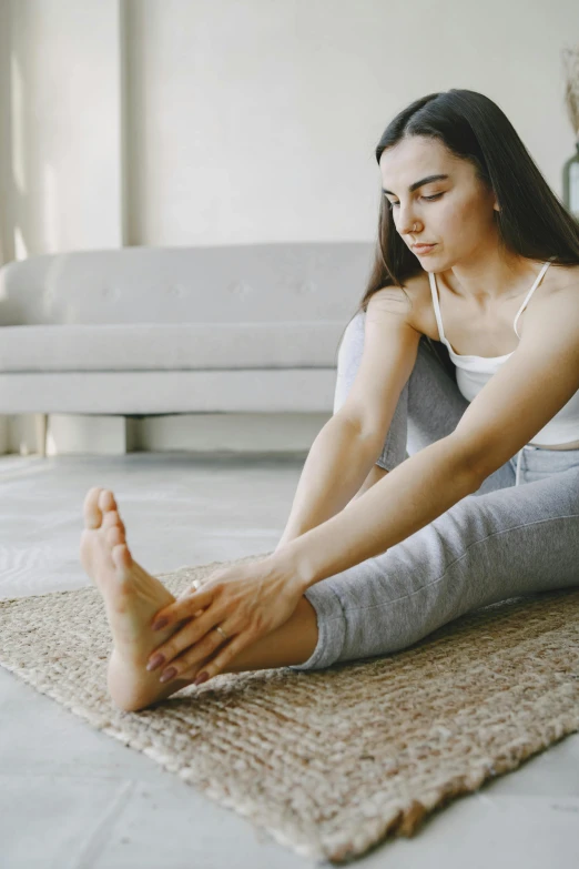 a woman is sitting on the floor while listening to headphones