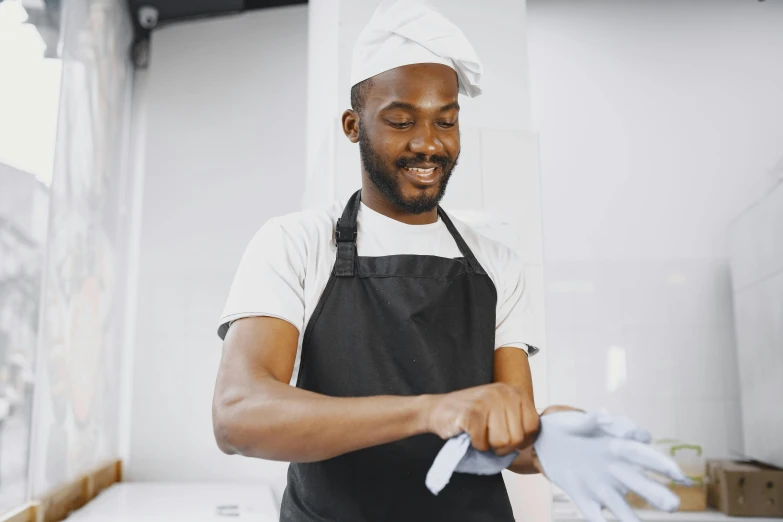 a man wearing an apron and holding soing in his hand