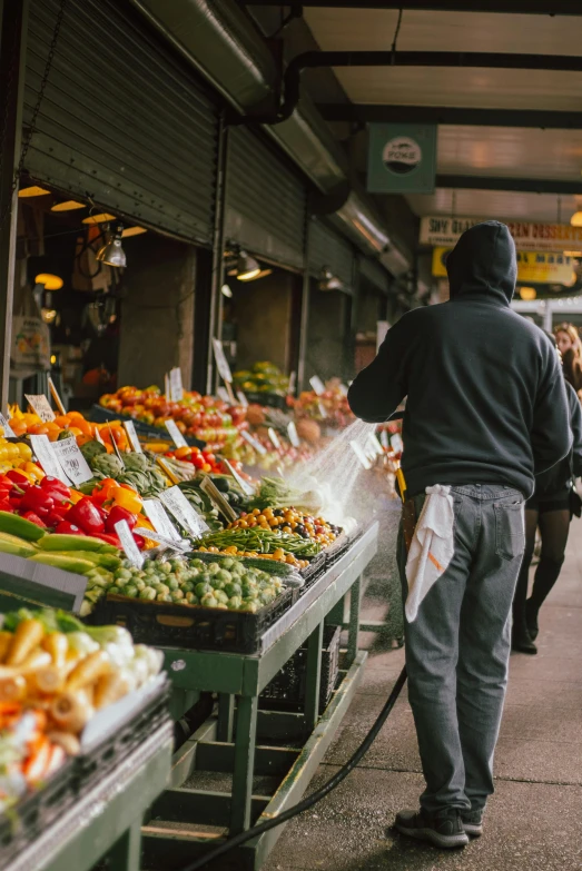 the man is walking by the vegetable stand