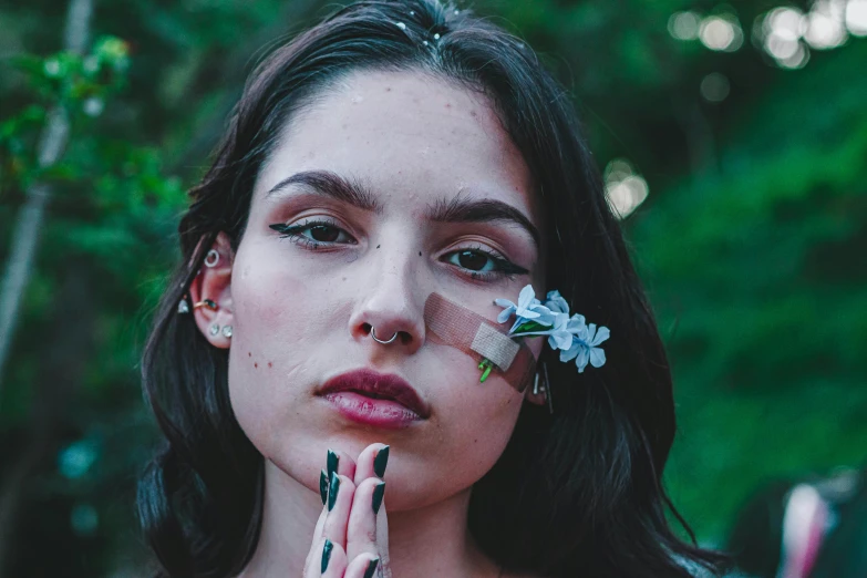 a woman holding up flowers with painted fingernails