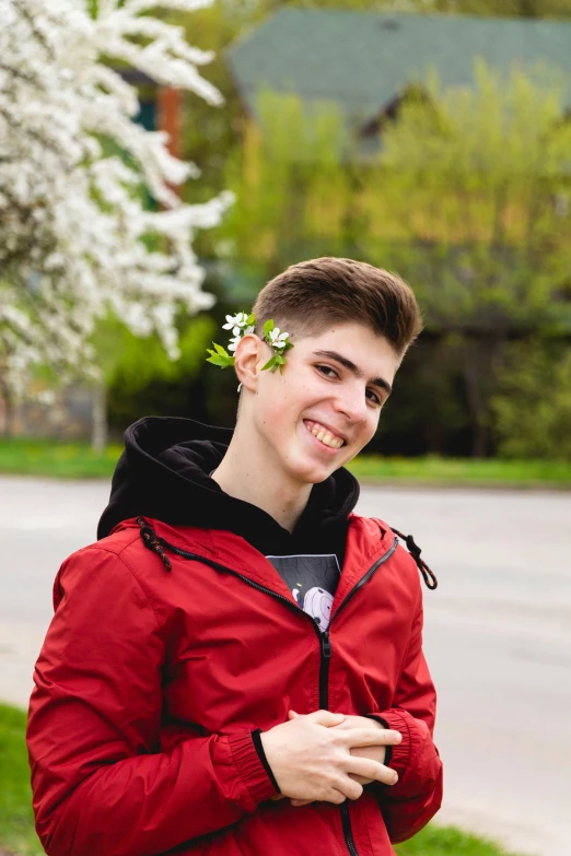 young man with flowers in his hair smiling for the camera