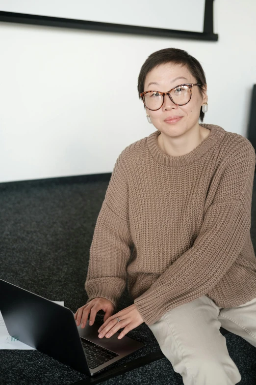 a woman sitting on a couch using a laptop