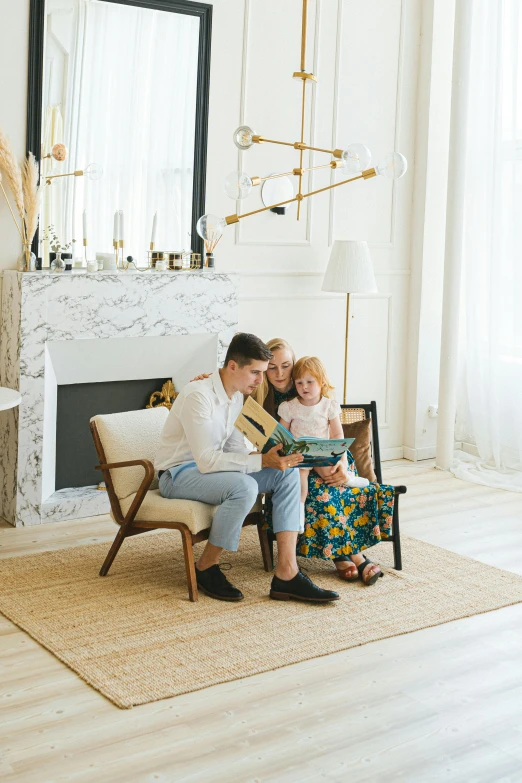 an adult and child reading a book next to a fireplace