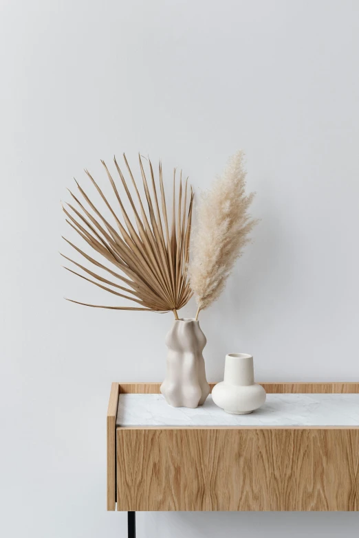 two white ceramic vases are on a shelf