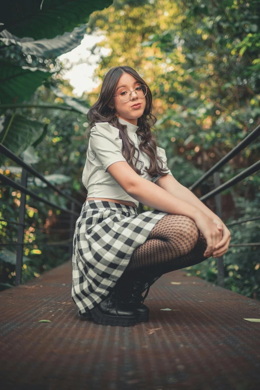 woman wearing black and white outfit sitting on brown tiled floor