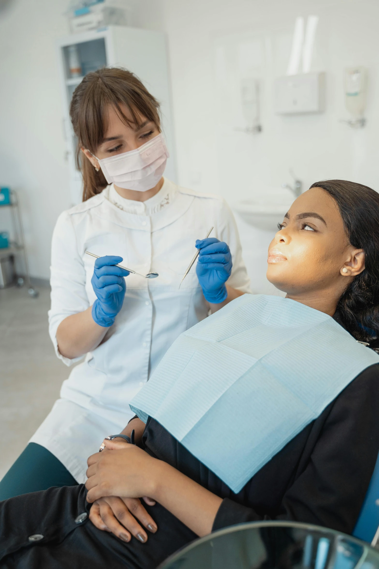 a woman getting her teeth brushed with a mask on