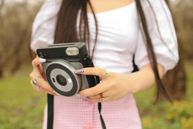 a person holding a camera near a field