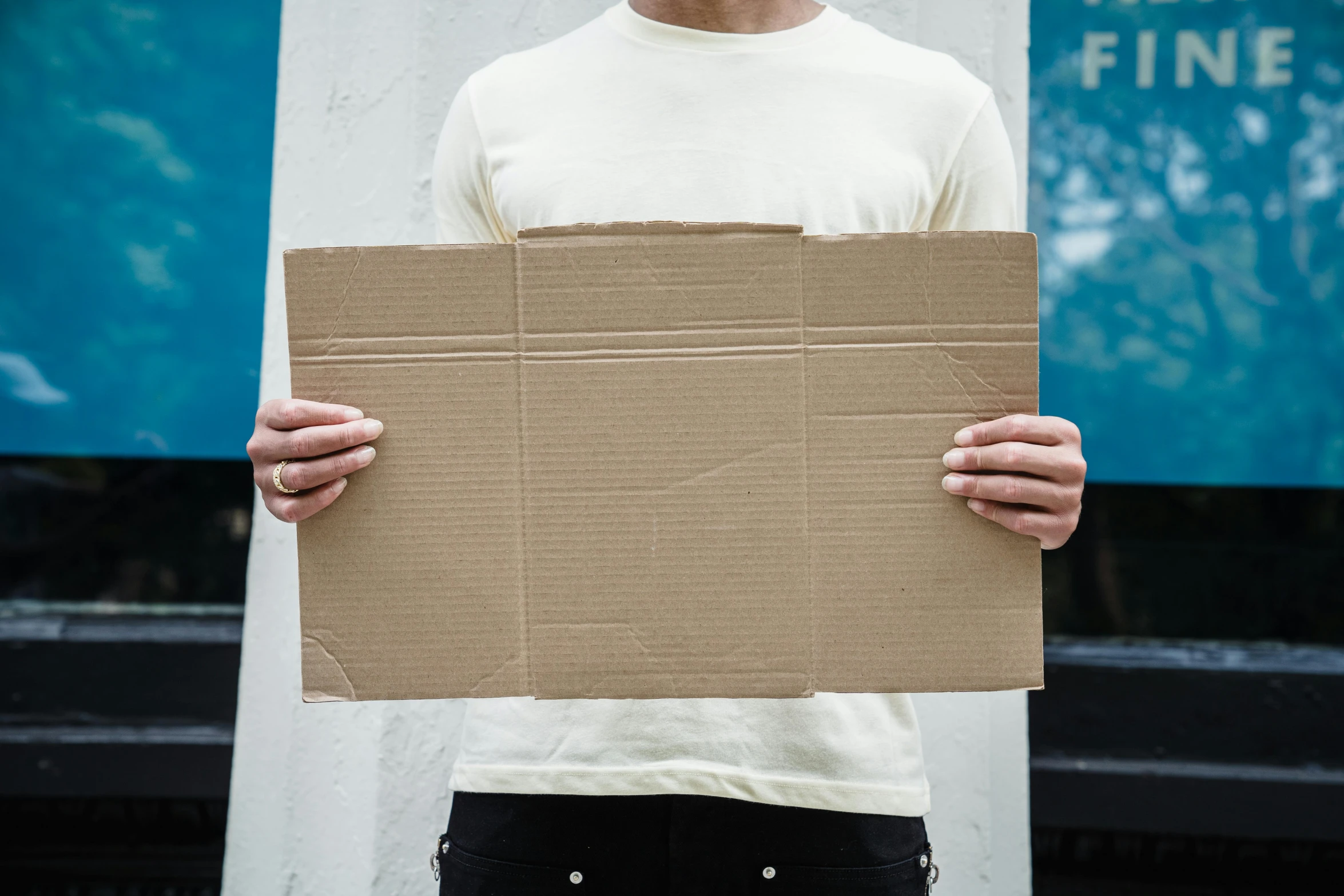 a man holding a piece of cardboard outside