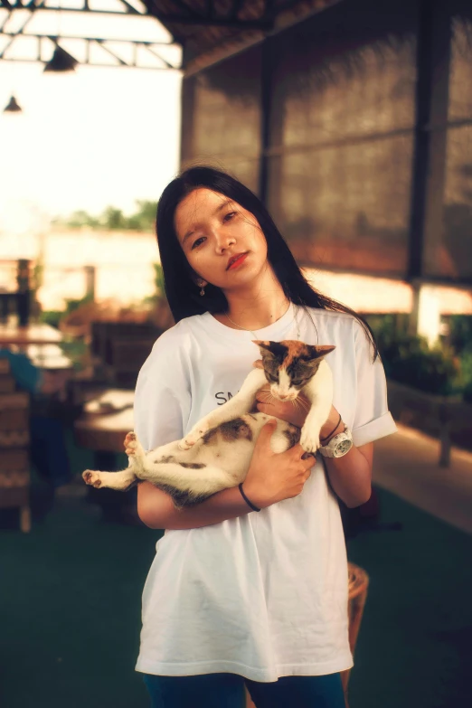 a woman standing with her cat on a porch