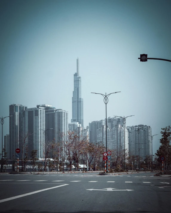 an intersection with a traffic light and large city in background