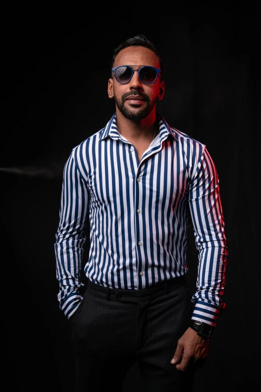 the man wearing shades and a shirt is posing for a po