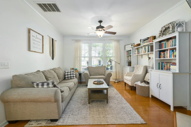 a living room with white walls and a brown floor