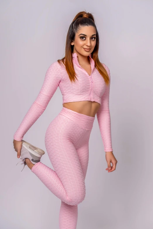 the woman is wearing pink clothing and posing for a po