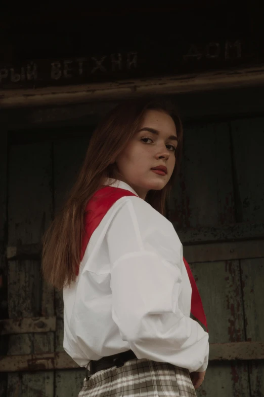 a girl is wearing plaid pants and a white blouse