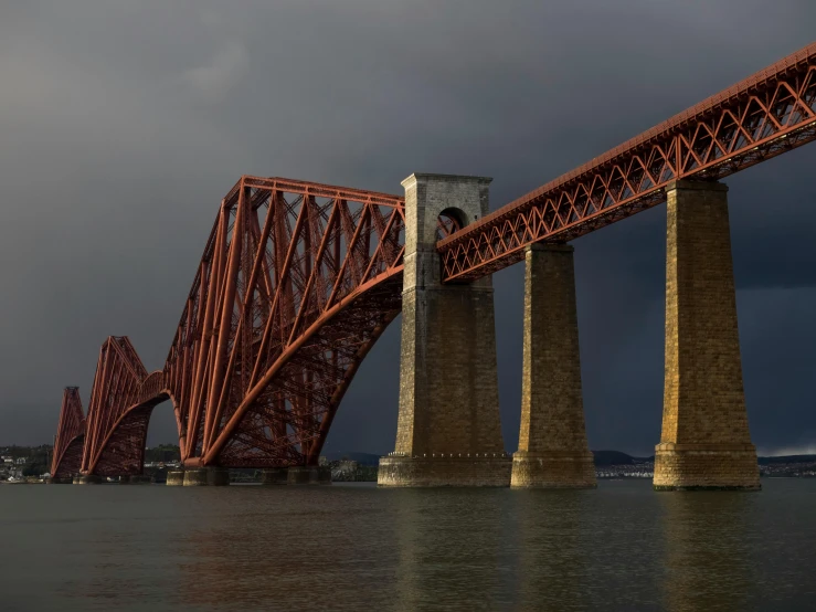 a large bridge is shown with dark clouds above