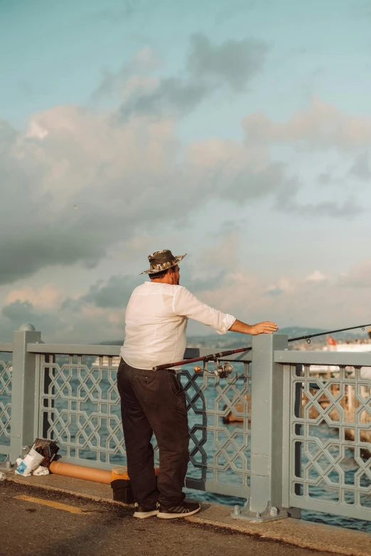 man leaning on the edge of the street with a sky background