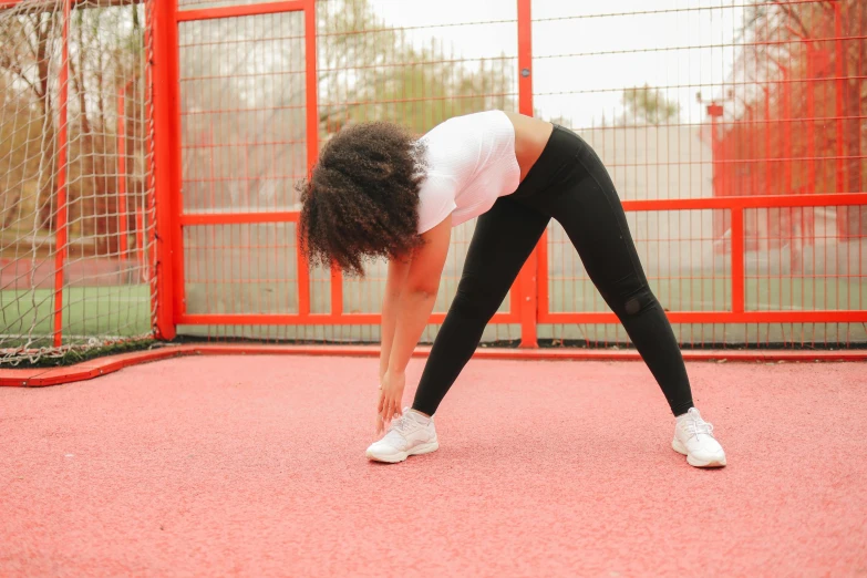 the woman is bent over doing yoga on the ground