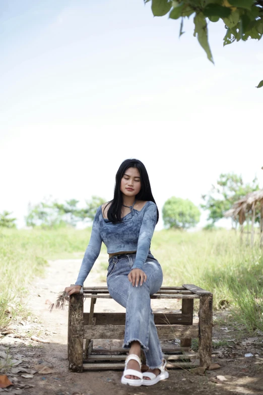 a woman is sitting on a bench outside