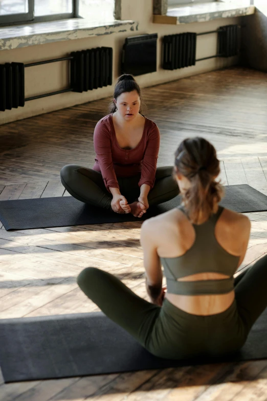 three woman practicing yoga in a large room