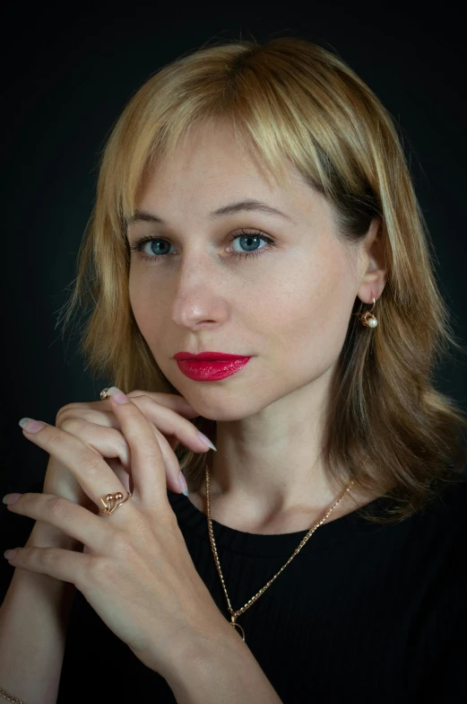 a woman with a ring and necklace is posing