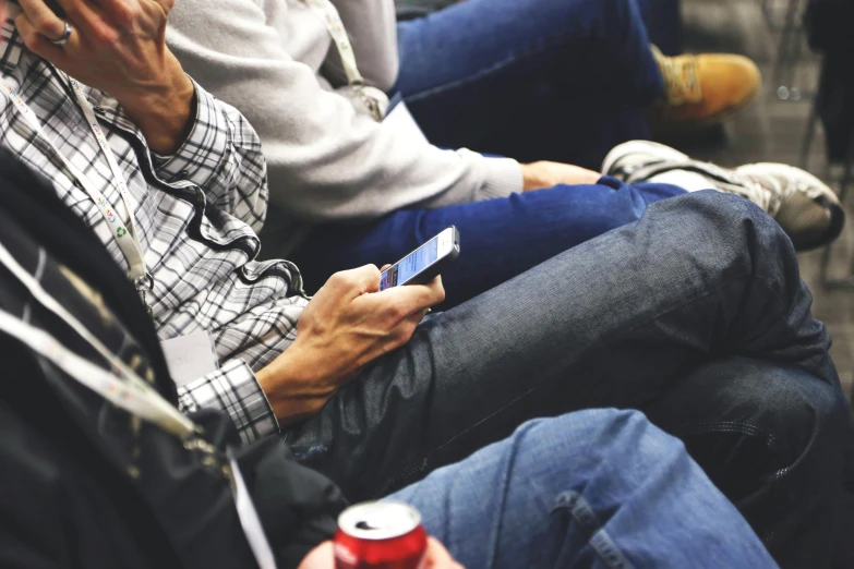 people sitting on a bus, using cell phones and drinking soda