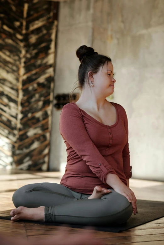 a woman meditating on the floor with her feet crossed in front of the ground