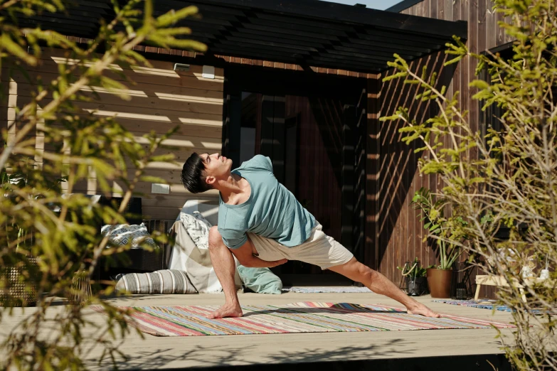 a man stretches on a porch with his feet on a rug