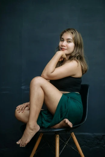 a woman sitting on top of a chair wearing green