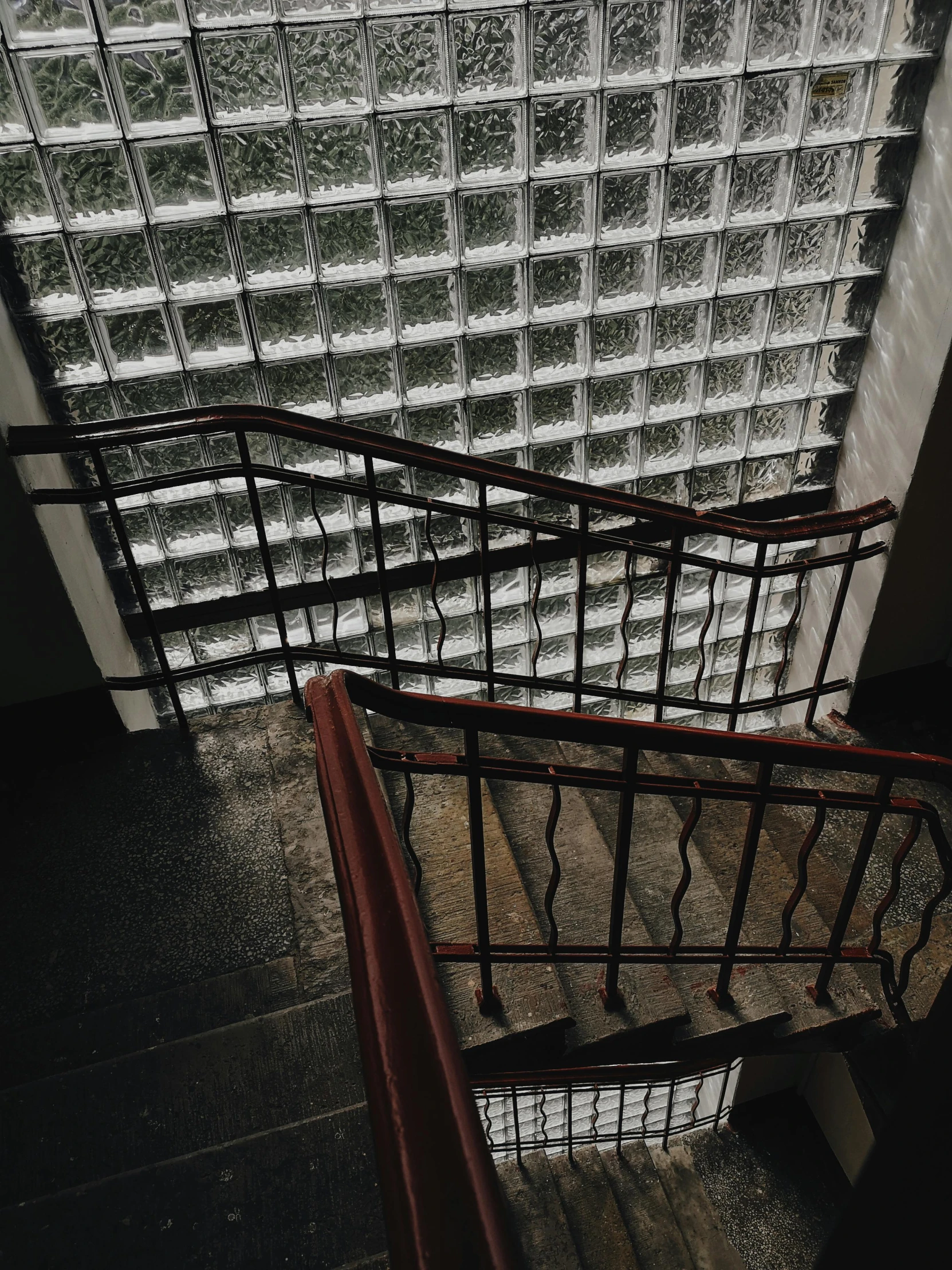 looking down the stairs at an empty glass cube