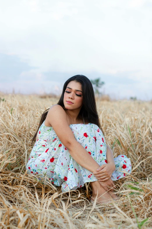 a woman in a dress sits on the ground