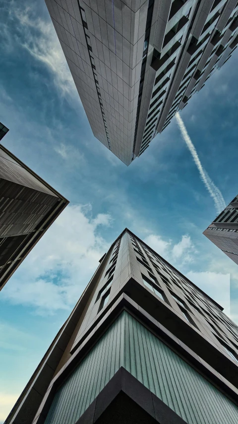 several tall buildings near one another under blue skies