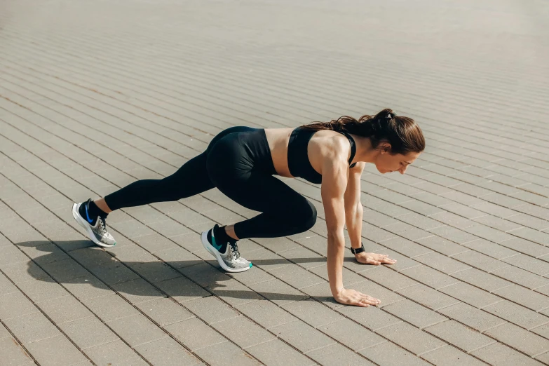 woman doing h ups while standing on a block sidewalk