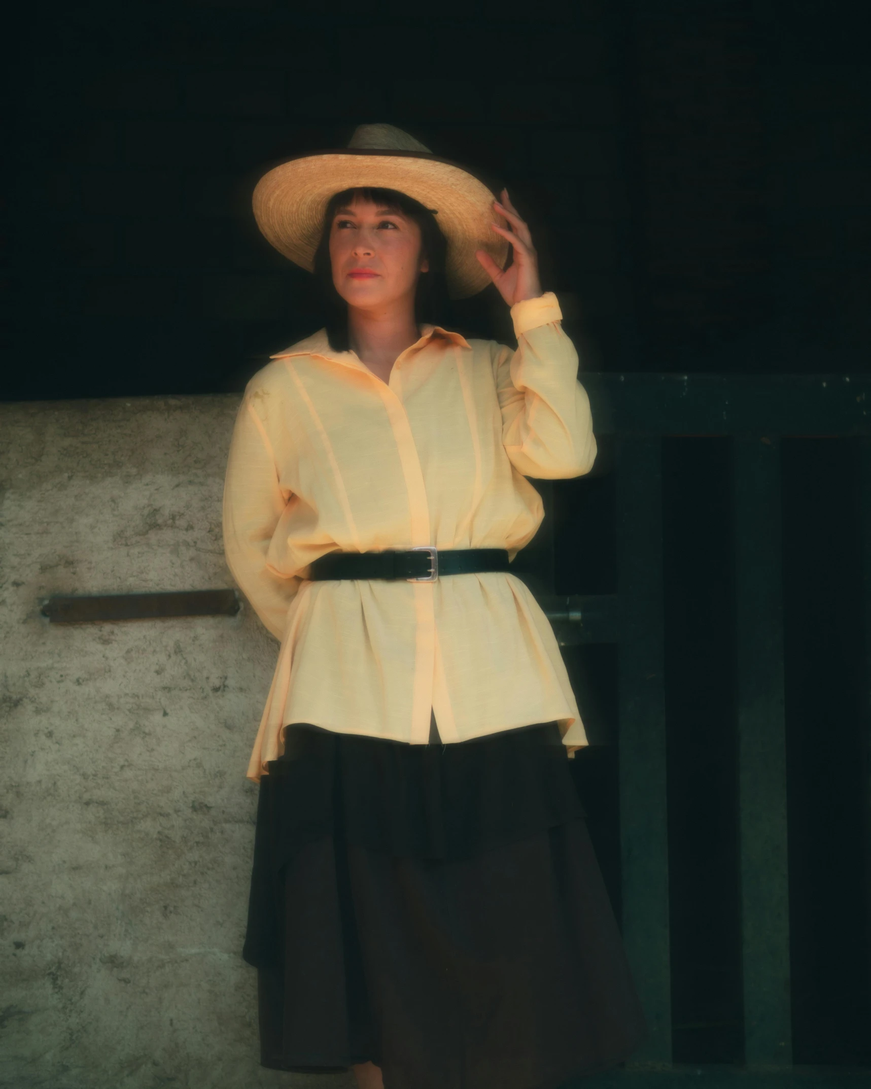 an image of woman in dress attire with hat standing in the dark