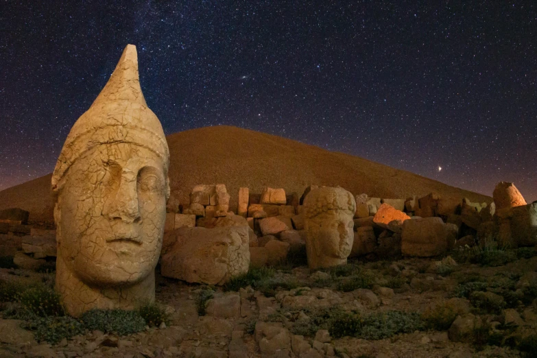 a large stone statue standing next to other small sculptures