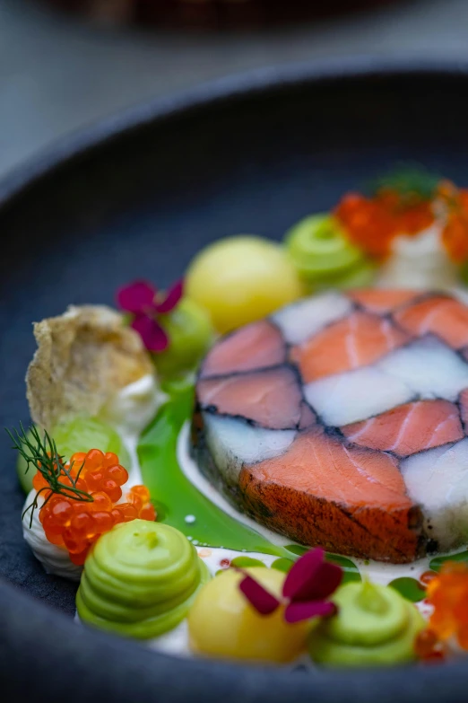 a plate with a piece of sushi, cucumber and some other food items