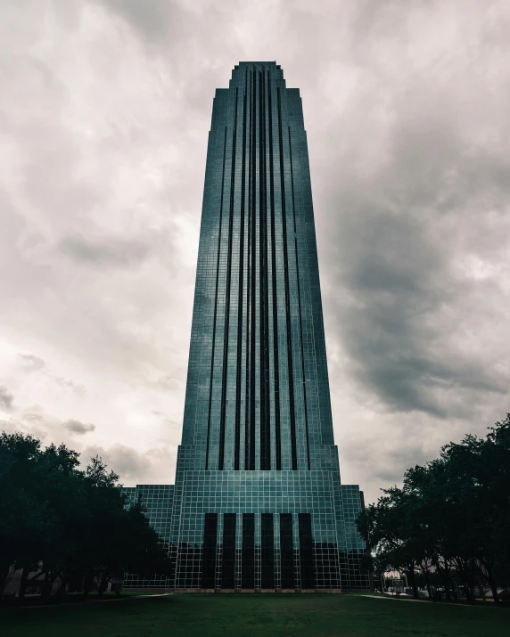 an art deco skyscr, surrounded by clouds and a park