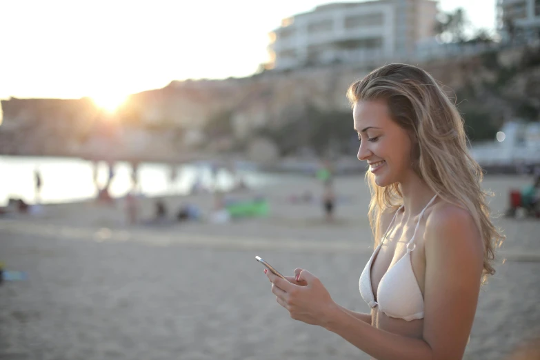 a woman on the beach looking at her phone