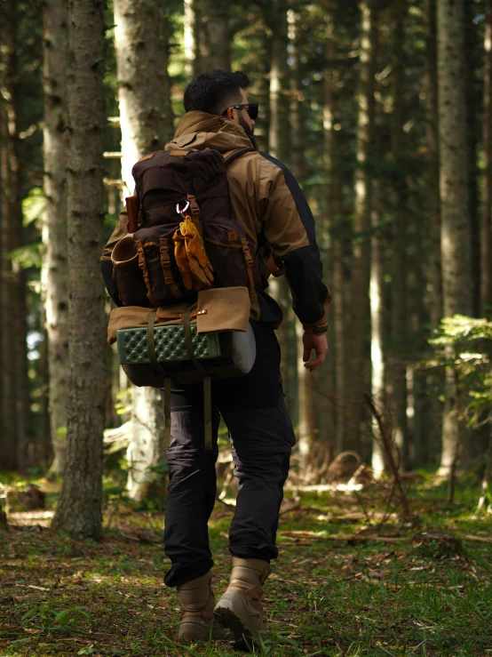 a man walking through a forest filled with lots of trees