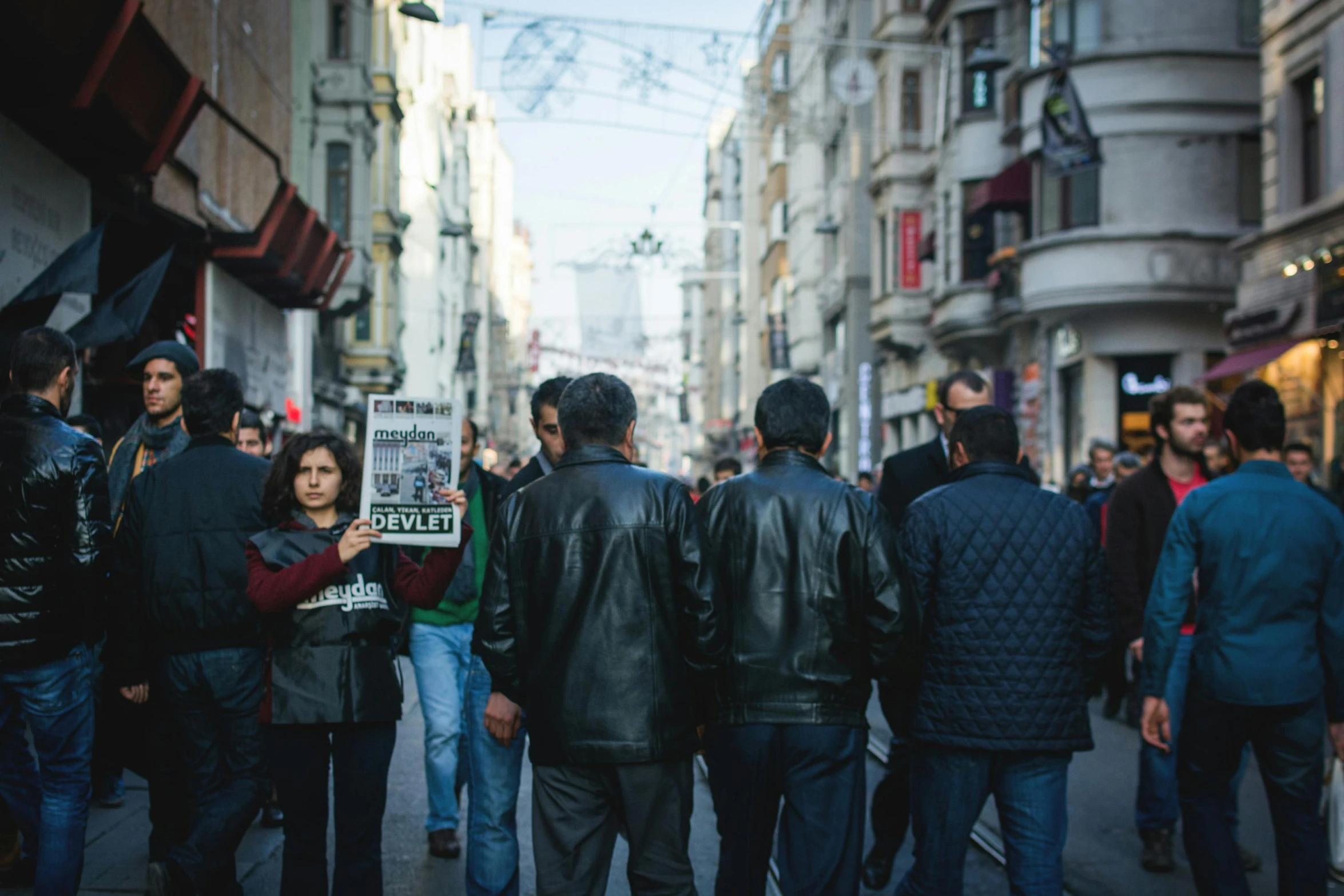 people in jackets and coats are gathered around a sidewalk