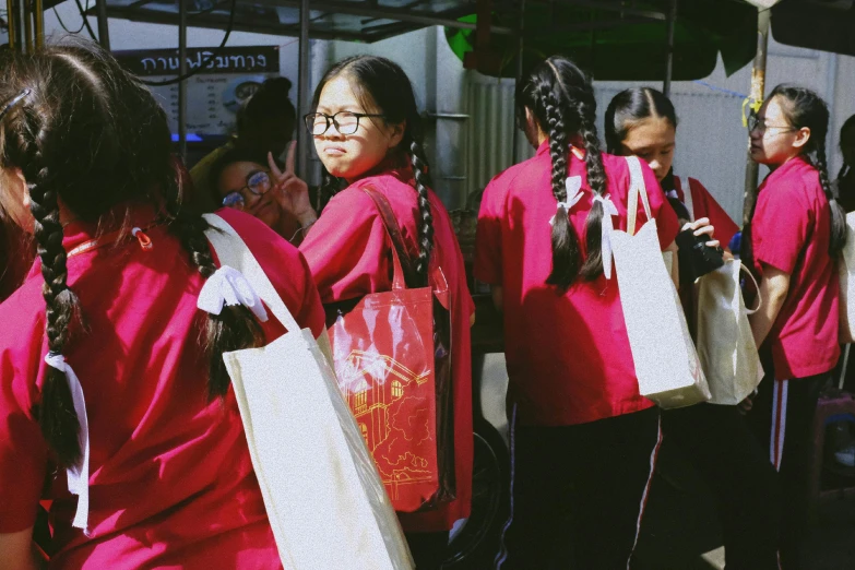 several girls are carrying some large bags