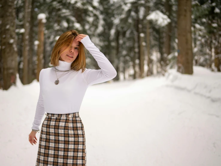 a woman stands in a forest with trees all around